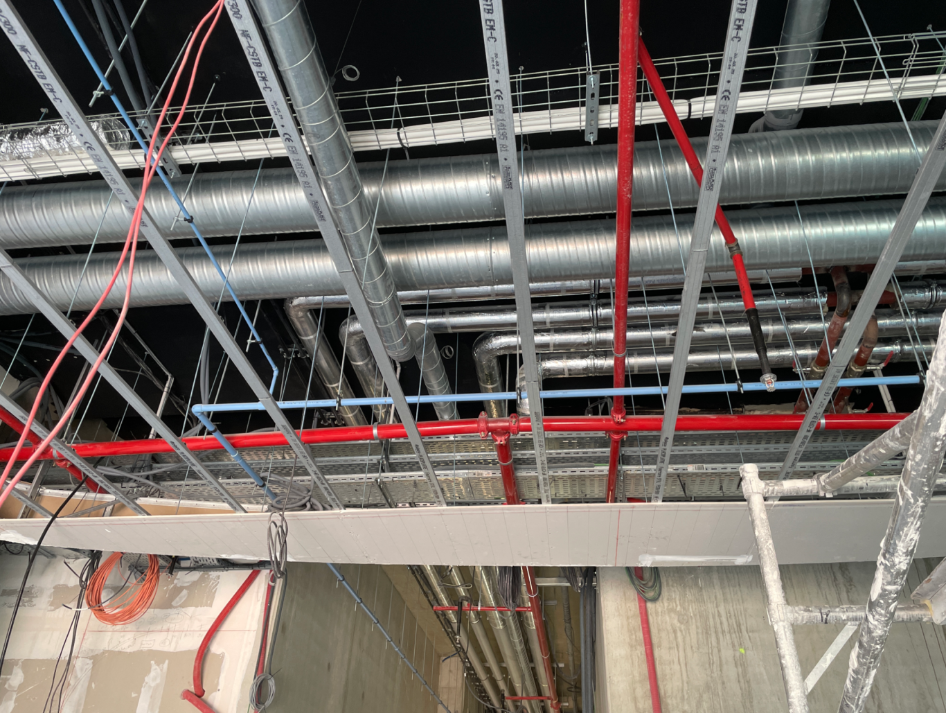 SYNING - SYNTHESE TECHNIQUE Structure de plafond avec conduits métalliques et éclairage.
